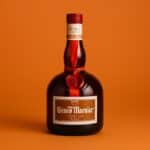 Bottiglia elegante di Grand Marnier su sfondo monocromatico arancione