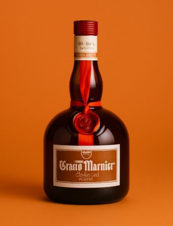 Bottiglia elegante di Grand Marnier su sfondo monocromatico arancione