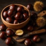 Castagne intere e aperte con ricci verdi e marroni su sfondo di legno grezzo