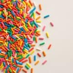 Codette zuccherate colorate sparse su superficie avorio