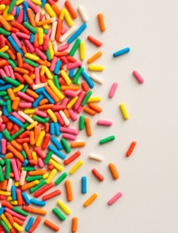 Codette zuccherate colorate sparse su superficie avorio