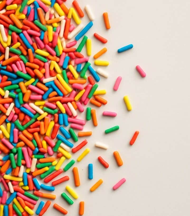 Codette zuccherate colorate sparse su superficie avorio