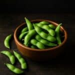 Edamame serviti in una ciotola di legno rustica su superficie in legno scuro