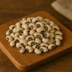 Mucchietto di fagioli dall’occhio con macchia nera su tagliere in legno