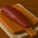 Filetto rosso scuro di capriolo su tagliere quadrato in legno rustico