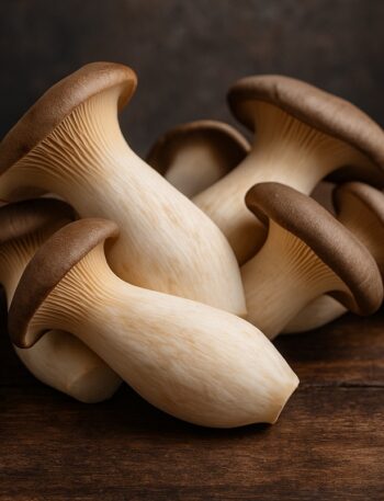 Gruppo di funghi cardoncelli con cappelli marroni e gambi chiari su tavolo in legno