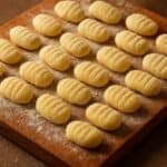 Gnocchi di patate disposti ordinatamente su tagliere rustico infarinato