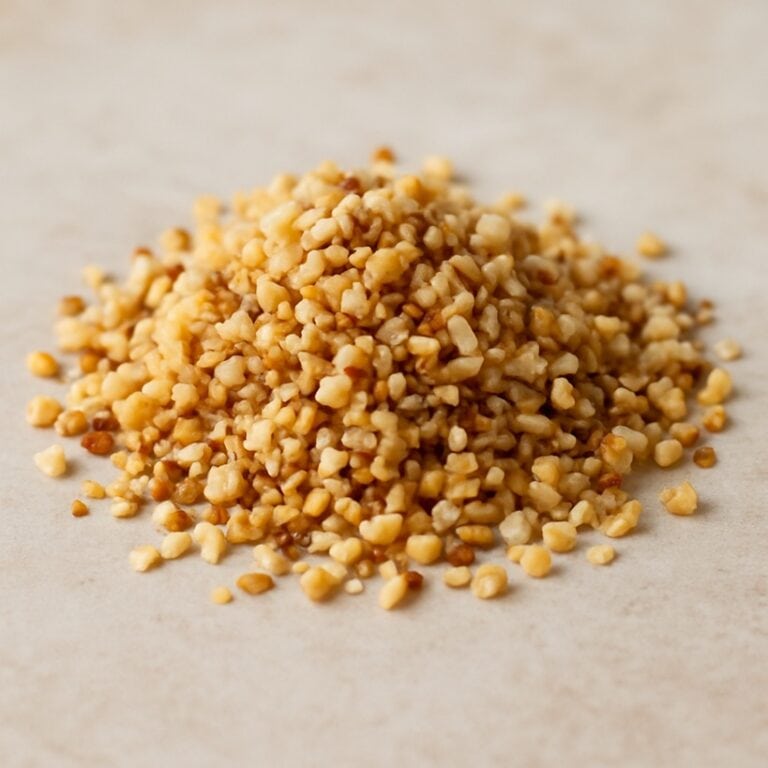 Granella di nocciole tostate su sfondo naturale chiaro