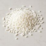 Granella di zucchero bianca su superficie in marmo chiaro