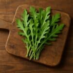 Mazzetto di rucola su tagliere in legno rustico