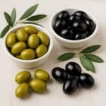 Olive nere e bianche in una ciotola di legno, pronte per essere servite.