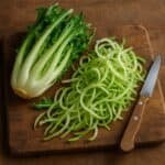 Puntarelle intere e a listarelle su tagliere in legno con coltello