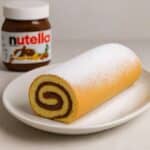 Rotolo alla Nutella su piatto bianco