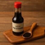 Bottiglia di salsa Worcestershire con scritta chiara su tagliere in legno