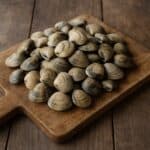 Vongole fresche su un tagliere di legno rustico