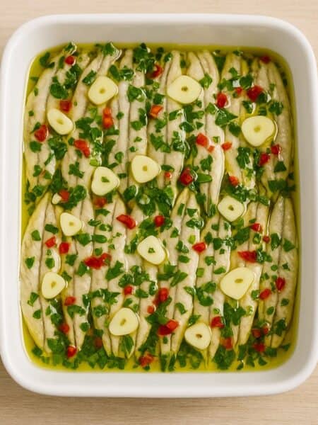 Alici marinate pronte al consumo condite in pirofila con olio e aromi