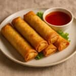 Involtini primavera fritti su piatto con salsa agrodolce