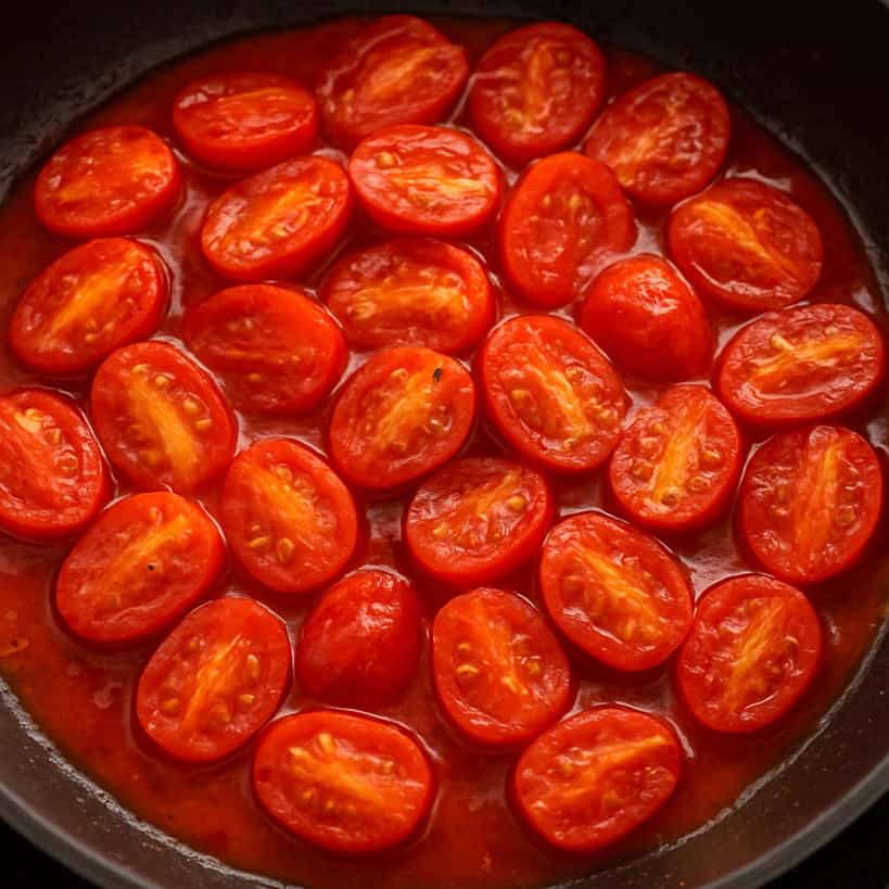 Pomodorini tagliati a metà e saltati in padella con sugo denso e lucido