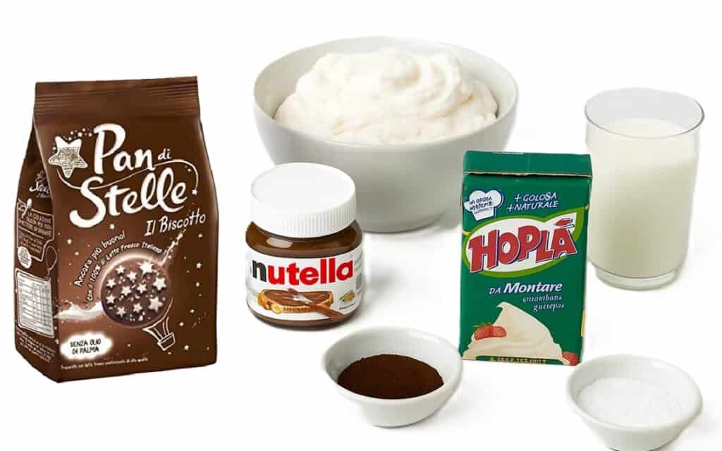 Tutti gli ingredienti per fare la torta pan di stelle: confezione di biscotti, nutella, panna, cacao, zucchero a velo e latte.