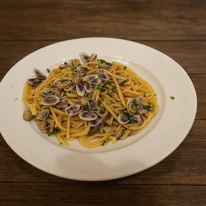Spaghetti con telline serviti su piatto bianco moderno