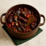 Boeuf Bourguignon in una cocotte tradizionale, con carne tenera, cipolline e funghi in un sugo ricco.