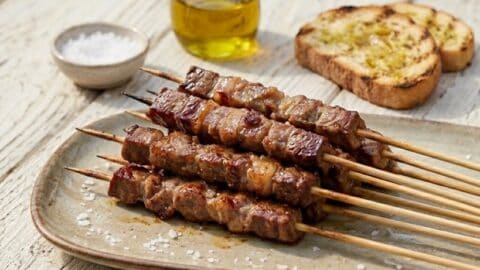 Arrosticini abruzzesi alla griglia con carne di pecora e pane casereccio